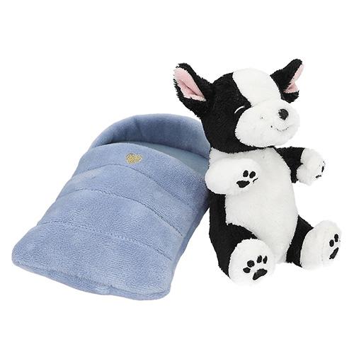 Top Model black and white plush dog in a blue sleeping bag
